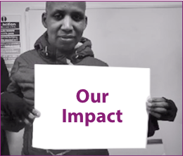 Person from Shaping Our Lives holding a banner with the words 'Our Impact'