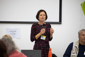 A photo of Becki Meakin, Involvement Manager at Shaping Our Lives. She is standing speaking into a microphone.